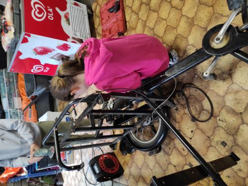 Britt bezig om de oude bakfiets uit elkaar te halen.