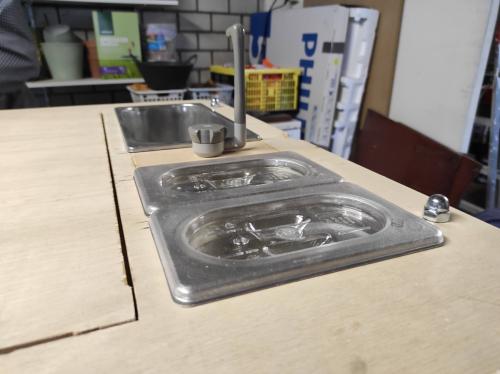 De bovenkant voorzien van de spoelbak en voorraad bakjes.